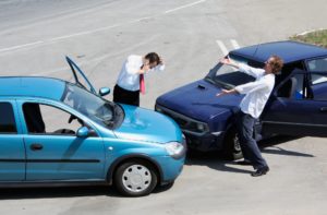 Traffic accident - one driver on the mobile phone, second expressing anger