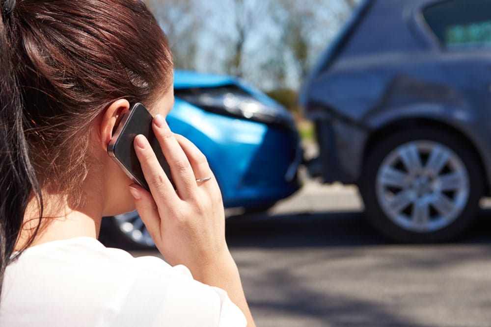 Woman On A Cell Phone After A Car Accident