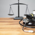 Personal injury law concept. The midsection of the judge's room has a gavel, stethoscope on the desk is a unique concept, symbolizing the intersection of justice, and health in a courtroom. copy space