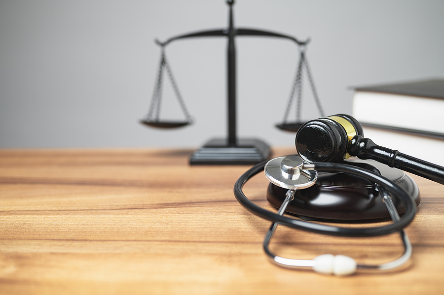 Personal injury law concept. The midsection of the judge's room has a gavel, stethoscope on the desk is a unique concept, symbolizing the intersection of justice, and health in a courtroom. copy space